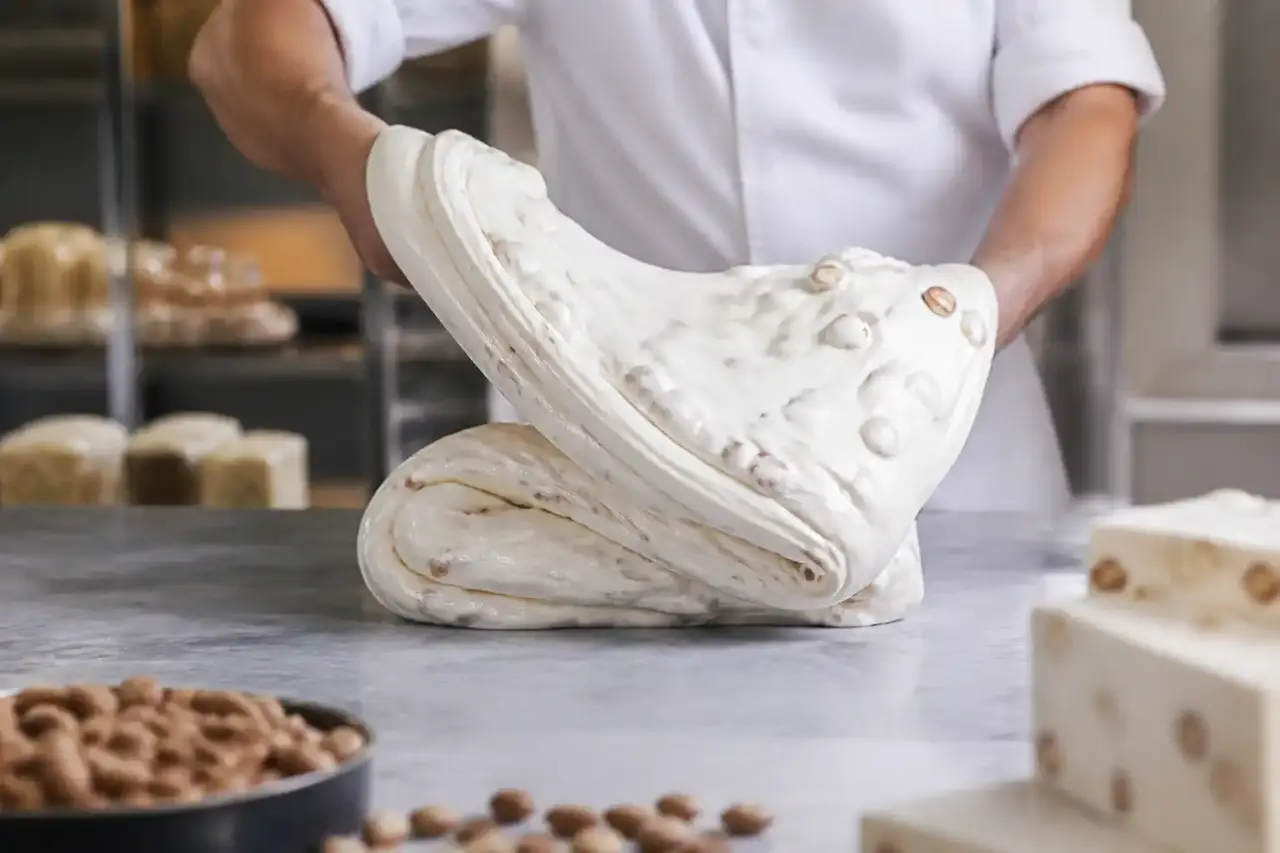 Préparation artisanale du nougat de Montélimar dans un chaudron de cuivre